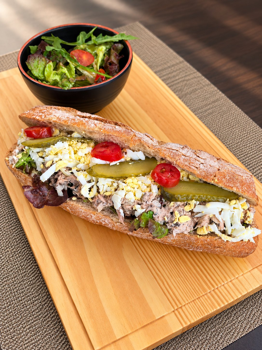 Sandwich thon méditerranéen sur planche avec salade